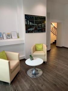 a waiting room with two chairs and a table at best business bühl - boardinghouse in Bühl