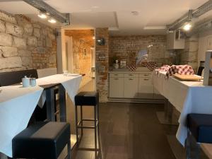a kitchen with white counters and brick walls at best business bühl - boardinghouse in Bühl