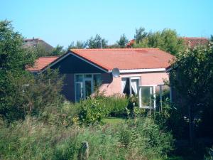 une petite maison avec un toit rouge dans l'établissement Ferienhaus Lisakowski, à Warmenhuizen