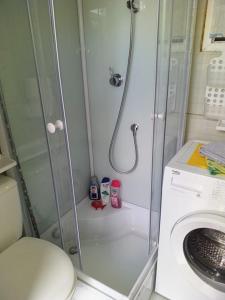 bagno con doccia e lavatrice di Two Rooms Cabin House (Self Check-In) a Bucarest