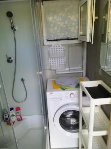 eine Waschmaschine in einem kleinen Bad mit Dusche in der Unterkunft Two Rooms Cabin House (Self Check-In) in Bukarest