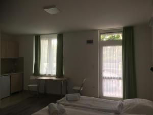 a bedroom with a bed and a window and a desk at Apartmanhotel Baraton*** in Balatonfüred +2 photos