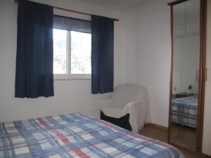 a bedroom with a bed and a chair and a window at Apartments Žuvela in Korčula