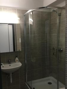 W łazience znajduje się szklana kabina prysznicowa i umywalka. w obiekcie Apartmanhotel Baraton*** w Balatonfüred