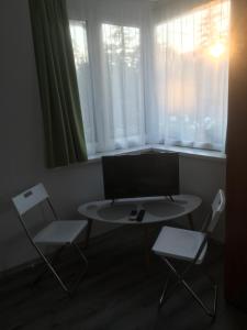 a room with a table and two chairs and a window at Apartmanhotel Baraton*** in Balatonfüred