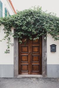 an open door leads to a large room with a large window at Jaca Hostel Porto da Cruz in Porto da Cruz