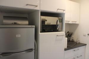 SUPERDEVOLUY STUDIO au 433S في لو ديفولي: ثلاجة في مطبخ مع ميكروويف