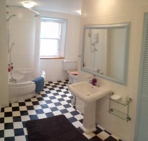 a bathroom with a sink and a tub and a toilet at Kirkview House in Moffat +25 photos
