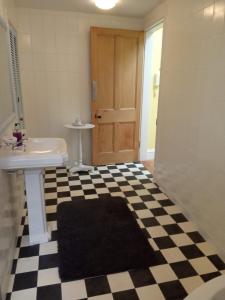 a bathroom with a black and white checkered floor at Kirkview House in Moffat