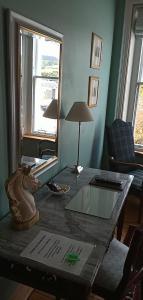 uma sala de estar com uma mesa com um candeeiro em Kirkview House em Moffat