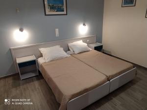 1 dormitorio con 1 cama con 2 almohadas en Moros Apartments, en Agios Stefanos