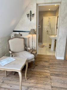 a room with a chair and a sink and a bathroom at L'ange est rêveur in Langeais