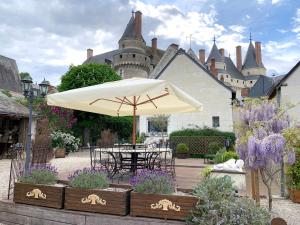 - une table avec un parasol en face d'un château dans l'établissement L'ange est rêveur, à Langeais