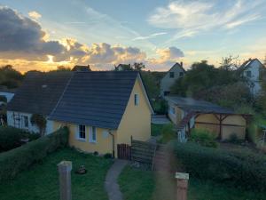 a yellow house with a black roof on a hill at Ferienhaus Nordstrand in Altenkirchen