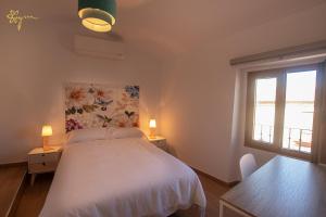sypialnia z białym łóżkiem i 2 oknami w obiekcie Apartamentos Turísticos AbrilyMarzo w mieście Cáceres