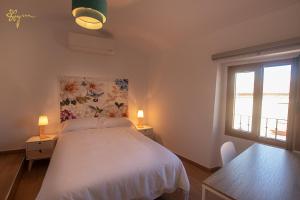 a bedroom with a white bed and two windows at Apartamentos Turísticos AbrilyMarzo in Cáceres
