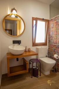 a bathroom with a sink and a toilet and a mirror at Apartamentos Turísticos AbrilyMarzo in Cáceres