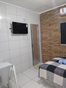 a bedroom with a bed and a flat screen tv at HOTEL CIDADE EXPRESS 24H in Teresina