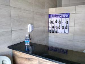 a bottle of water sitting on a counter in a bathroom at HOTEL CIDADE EXPRESS 24H in Teresina