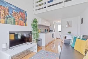 a living room with a couch and a kitchen at On the Water 2 with Free Parking - By My Getaways in Brighton & Hove