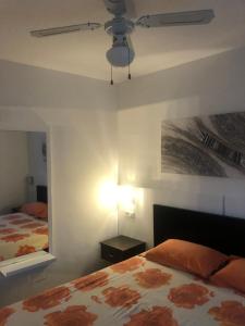 1 dormitorio con 1 cama y ventilador de techo en Los tunos campo internacional, en Maspalomas