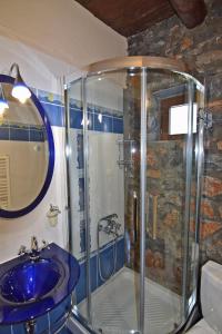 a bathroom with a shower and a blue sink at Luxurious Residence at the Village Square in Palaios Agios Athanasios