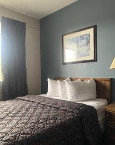 a hotel room with a bed and a window at Bancroft Inn & Suites in Bancroft