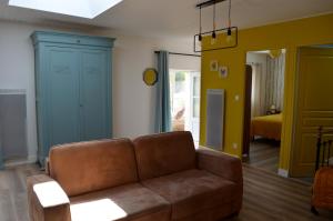 een woonkamer met een bruine bank en blauwe kasten bij Maison de caractère proche des Sables d’Olonne in Talmont