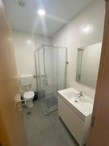 Un baño con ducha, lavabo e inodoro. en Casa Faneca - Faneca Apartamentos, en Nazaré