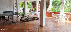 a patio with a glass table and white chairs at Hotel Campestre UMPALÁ in San Gil