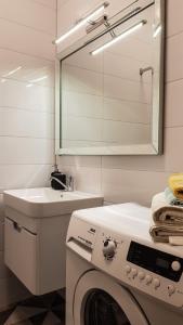ein Badezimmer mit einer Waschmaschine und einem Waschbecken in der Unterkunft Old Kaunas Apartment in Kaunas