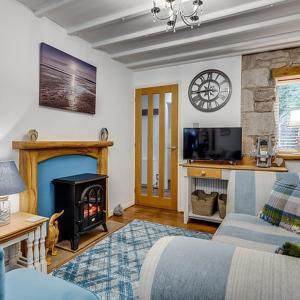 a living room with a couch and a fireplace at Coachhousebungalow in Grange Over Sands