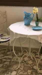 una mesa blanca con un jarrón azul encima en Casa Vacanze Flavia, en Palermo