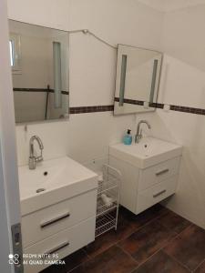uma casa de banho com dois lavatórios e dois espelhos em Fotis Apartments em Skála Néon Kydonión