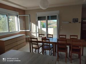 eine Küche und ein Esszimmer mit einem Tisch und Stühlen in der Unterkunft Fotis Apartments in Skála Néon Kydonión