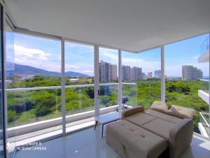 uma sala de estar com um sofá e janelas grandes em Apartamento en Santa Marta, hermosa vista. em Santa Marta