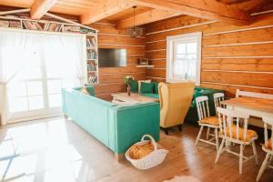 a living room with wooden walls and a table and chairs at Kolíska pokoja in Osturňa