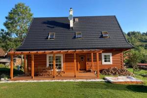 a log cabin with a porch and a deck at Kolíska pokoja in Osturňa