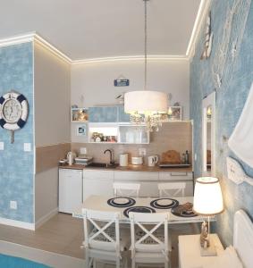una cocina con una mesa y una estufa horno superior en Apartament Marina, Villa Marea, en Międzyzdroje