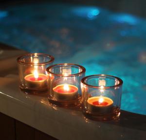 three candles sitting on a table next to a pool at Hotel U Hrabenky in Telč