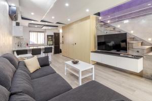 un soggiorno con un divano e una grande TV di Bahia Meloneras a San Bartolomé