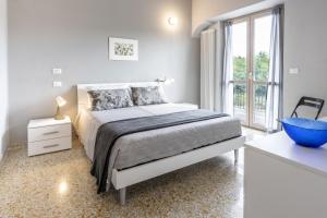 Dormitorio blanco con cama y ventana grande en 018 - Appartamento Il Lemme - Nel Cuore di Gavi, en Gavi