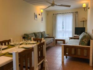 sala de estar con mesa de comedor y sofá en Las Caracolas Apart Familiar en Pinamar