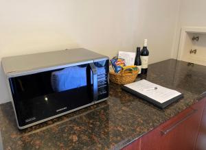 a microwave sitting on a counter with a bottle of wine at Best Western Plus All Settlers Motor Inn in Tamworth