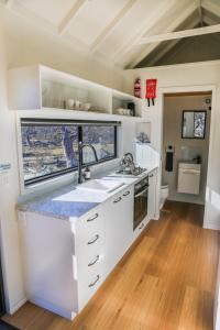 a kitchen with a sink and a counter top at Big Yard Escapes - Two Off-Grid Tiny Houses on the Mowamba River in Jindabyne
