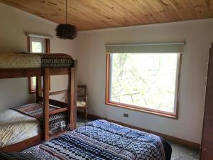 a bedroom with two bunk beds and a window at Cabañas del pillan in Pucón +30 photos