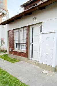 a garage with a white door and a window at Loft Amarillo in Tandil