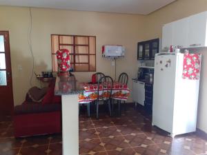 a kitchen with a table and a white refrigerator at Casa azul in Alto Paraíso de Goiás