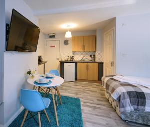 Habitación pequeña con cama, mesa y sillas en Grey Stone Studio Apartments en Halifax