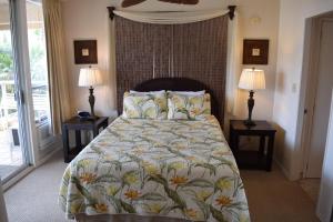a bedroom with a bed and two lamps on tables at Maui Banyan G310B in Wailea +13 photos